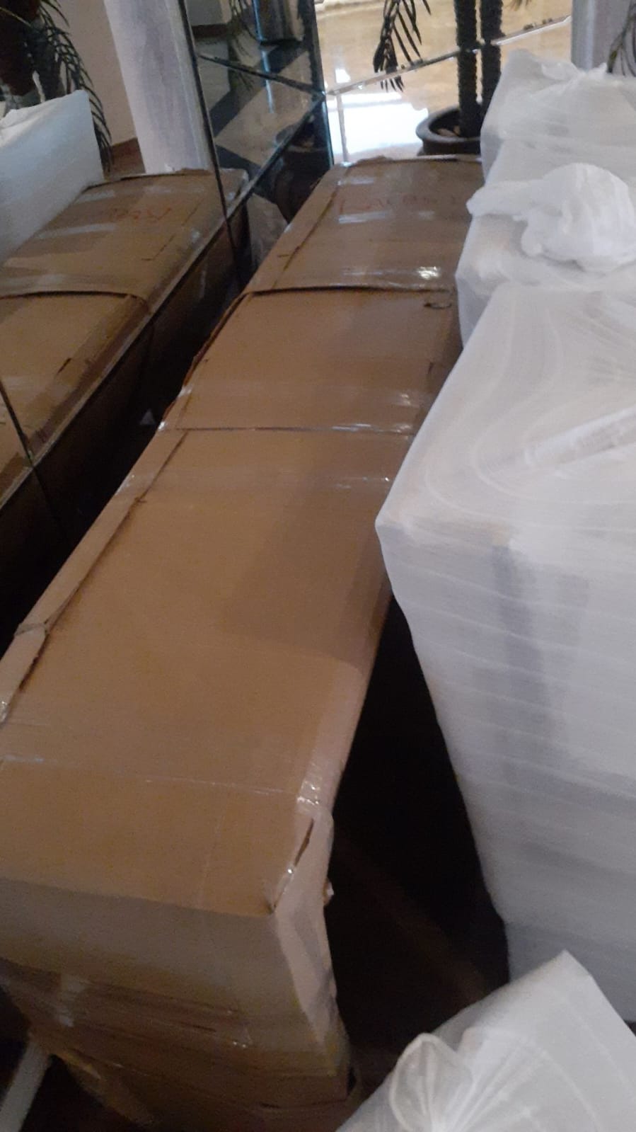 Caixas de papelão e móveis embalados com plástico filme prontos para transporte.